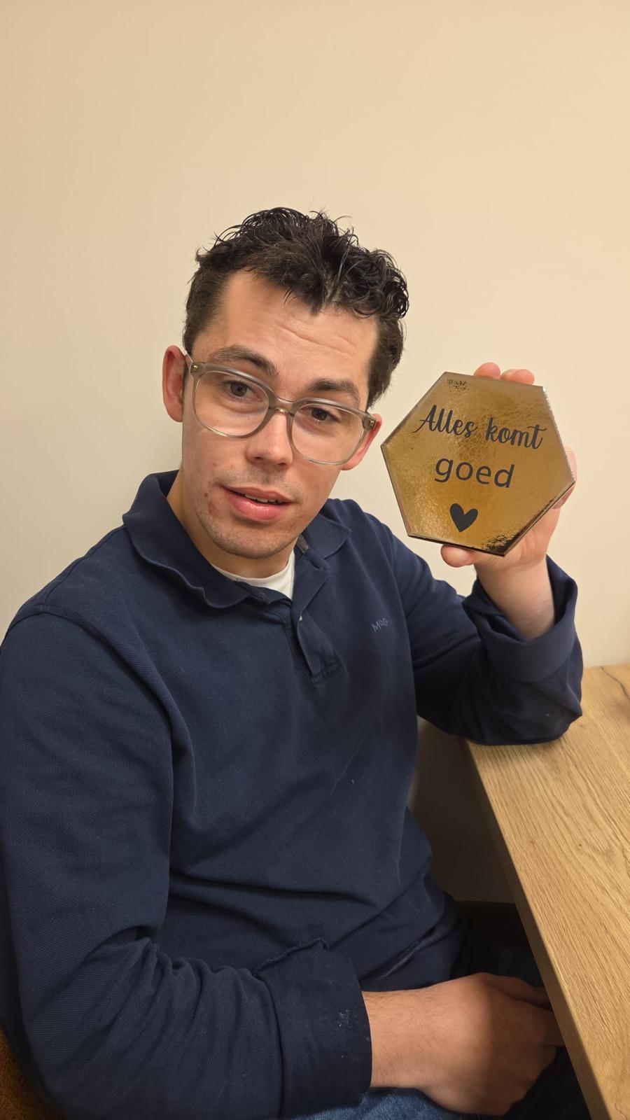 Medewerker toont een handgemaakt tegeltje